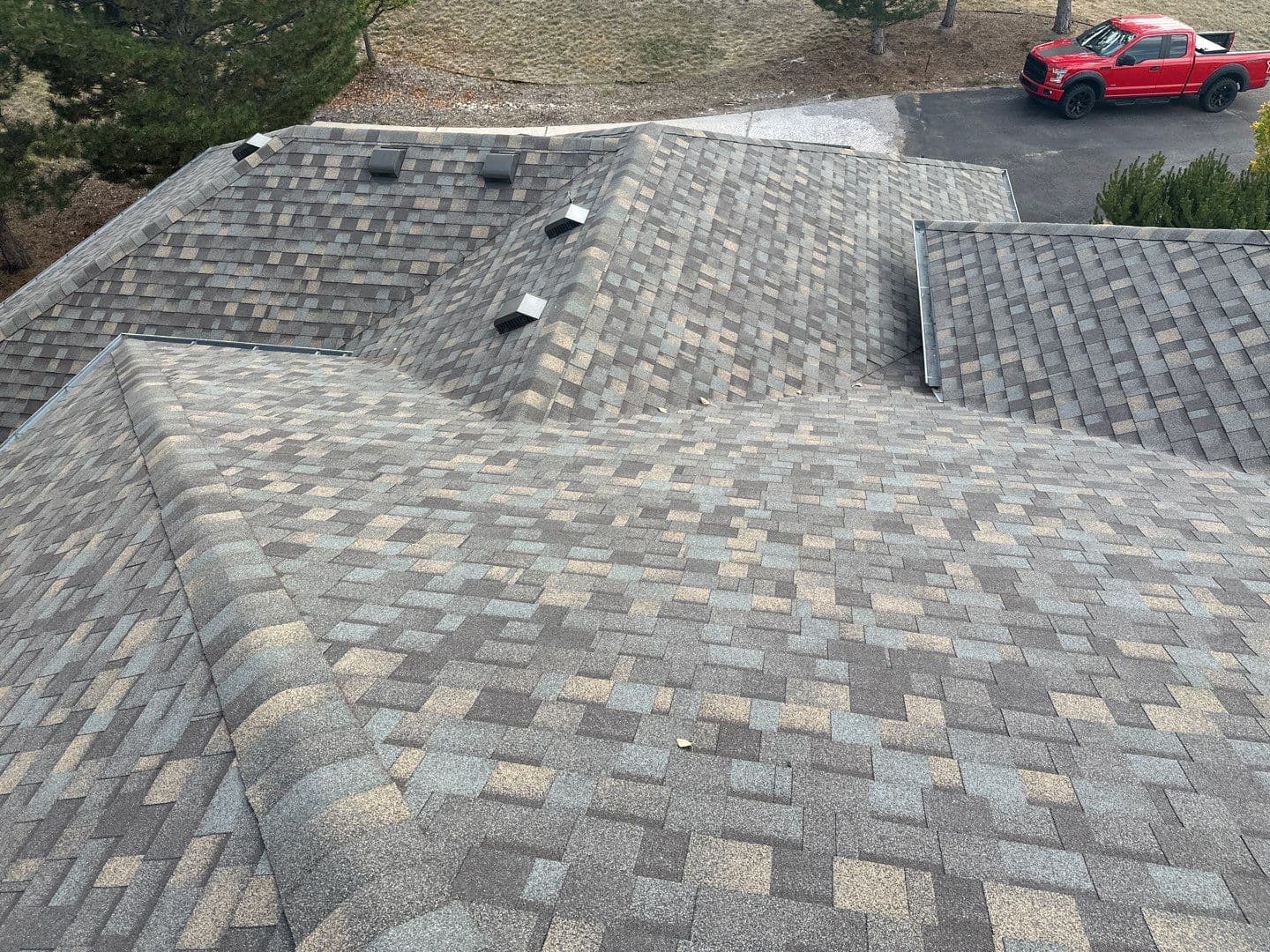 Aerial view of multi-plane architectural shingle roof replacement with gray and brown blend shingles