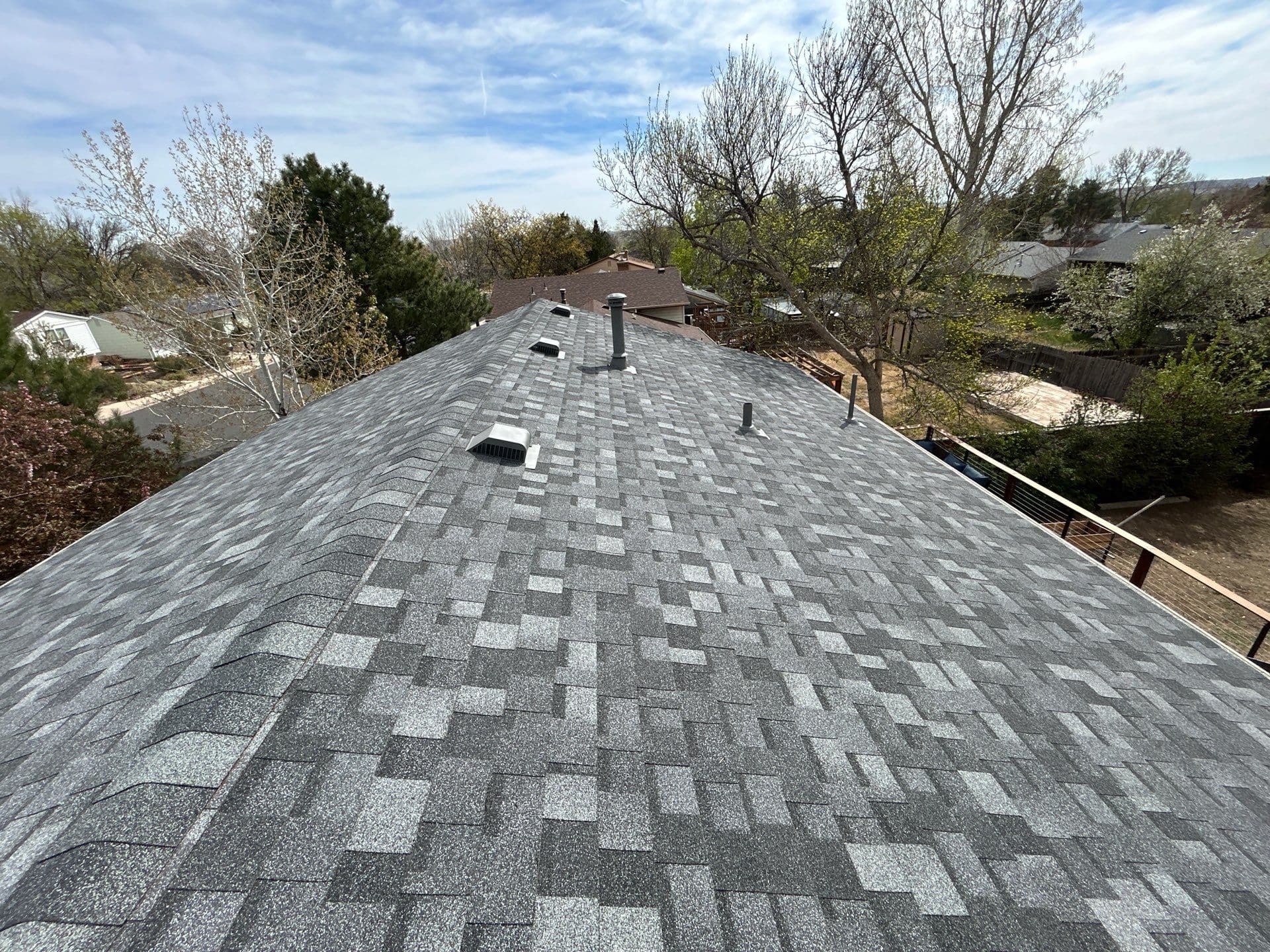 Completed residential roof replacement with gray architectural shingles and roof vents, aerial view Colorado