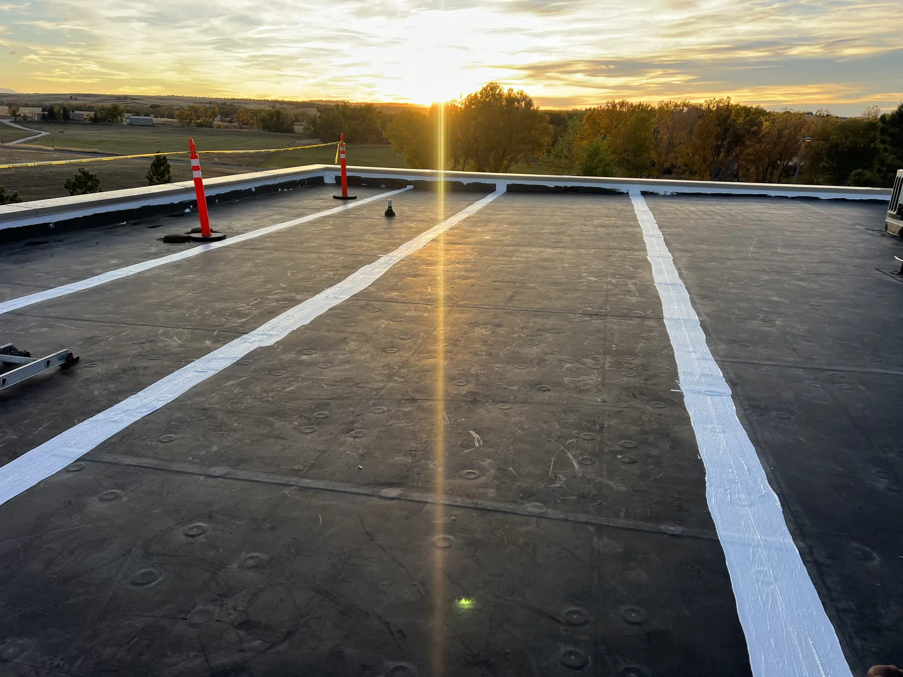 New flat roof membrane with sealed seams at sunset on a commercial building