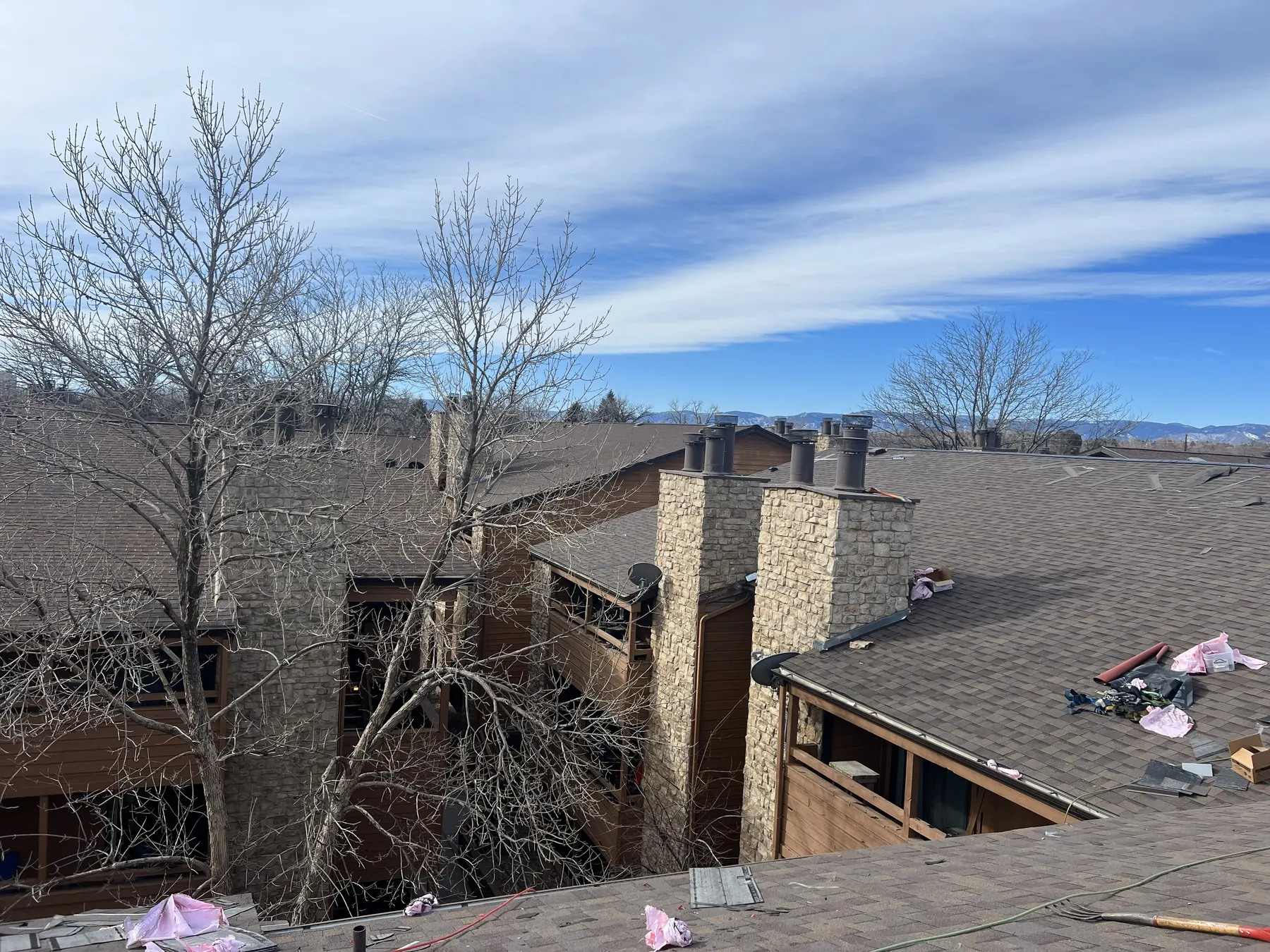 Gen 3 crew replacing the roof on a multi-family building with a chimney